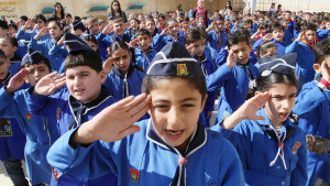 In this Wednesday, Sept. 18, 2013 photo, Syrian students salute while listening to the national anthem before entering their classrooms in Hassan Shuaib School in Damascus, Syria. Facing extraordinary challenges, millions of Syrian children in government controlled areas returned to school this week to the backdrop of a raging civil war and an international debate over Syria’s chemical weapons stockpile.(AP Photo)